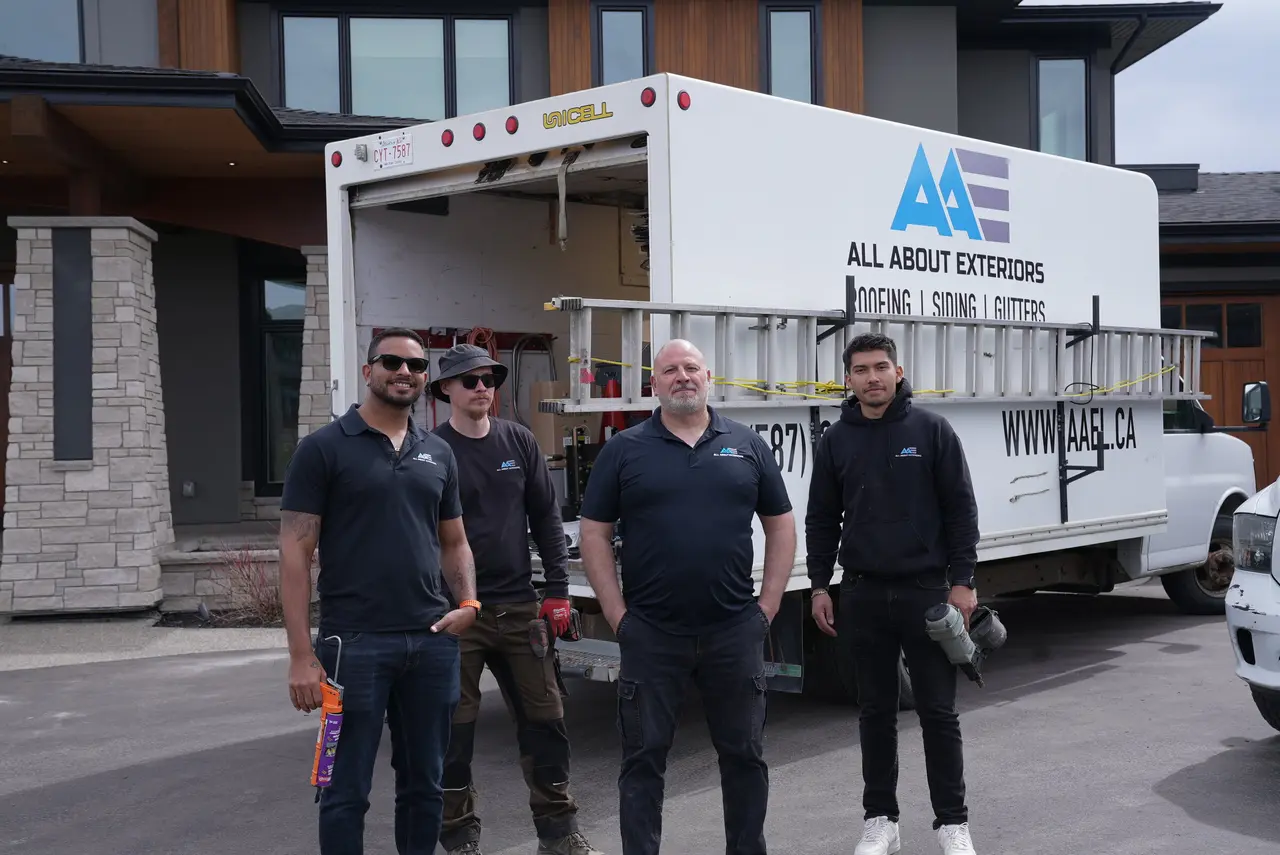 Four members of the All About Exteriors crew in front of the company truck at a finished Calgary home