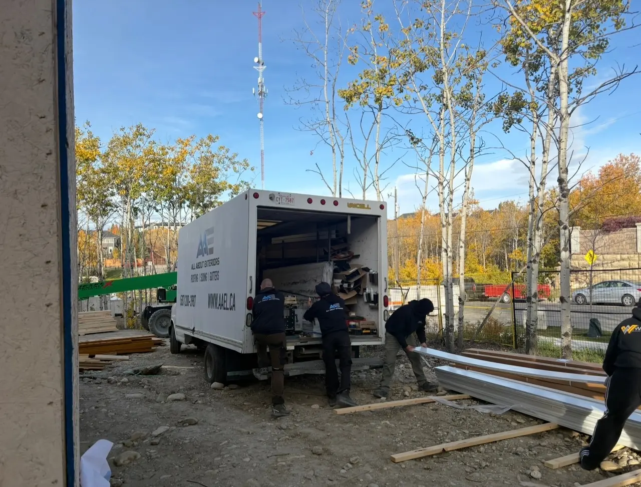 The All About Exteriors crew unloading siding from the company box truck at a job site