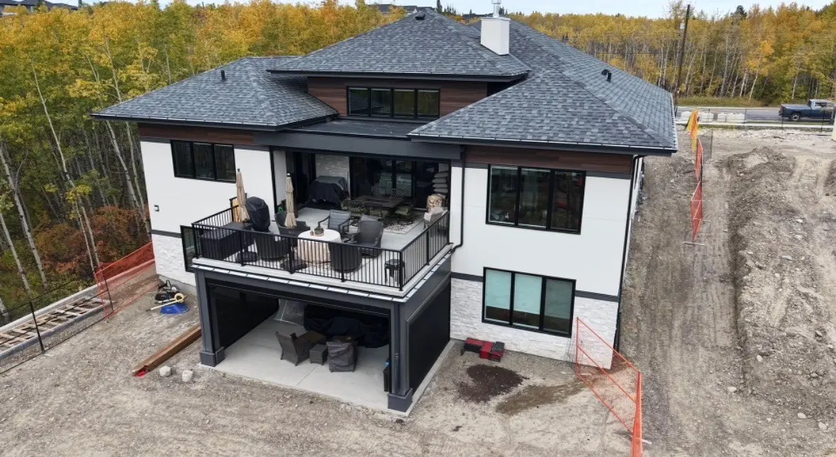 Custom home with a covered rear deck, white stucco and stone, and a new shingle roof