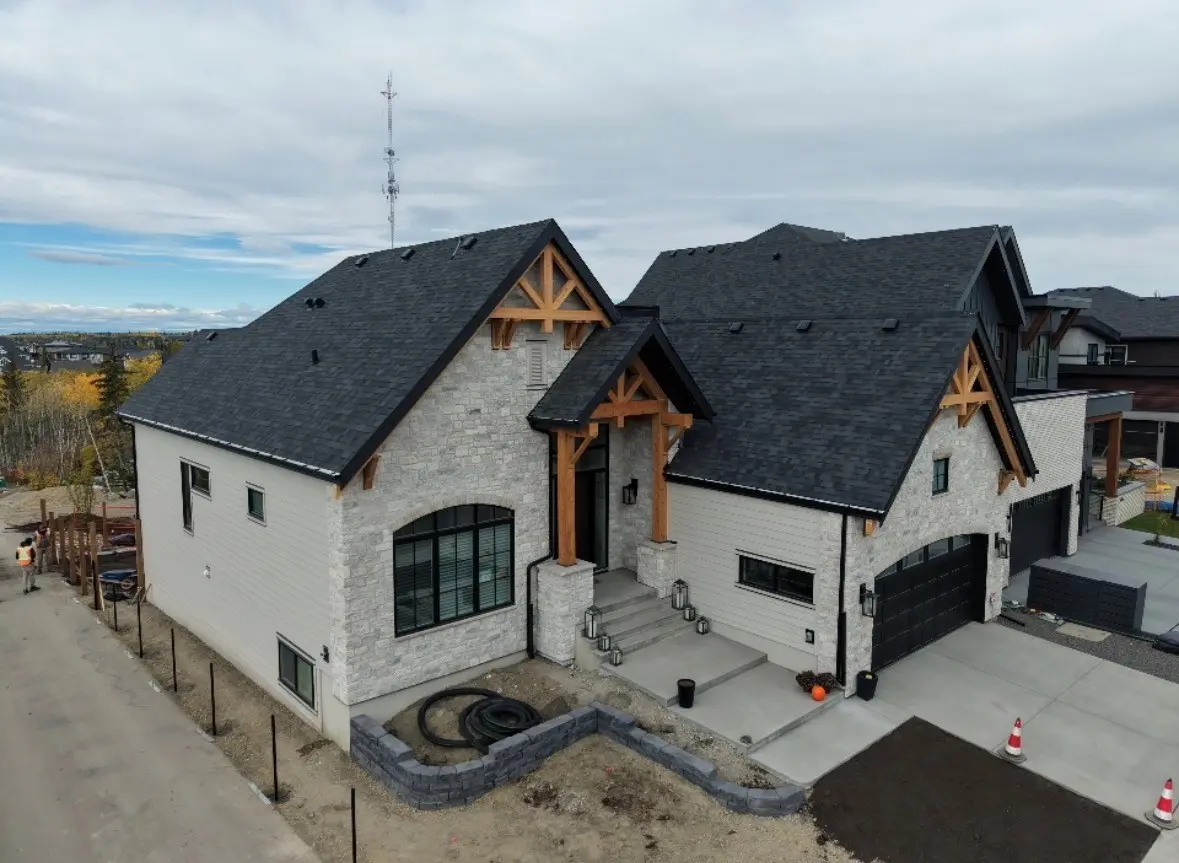 Custom home with stone, timber frame entry and a new dark shingle roof