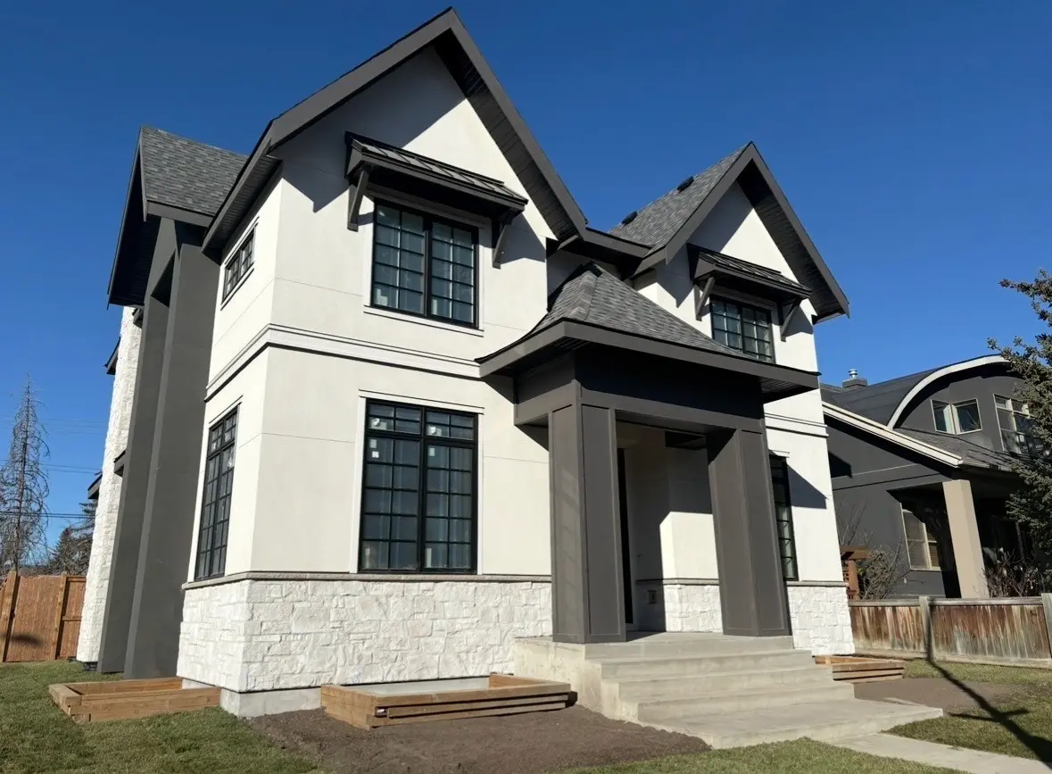 Two storey home with dark board and batten siding and black windows