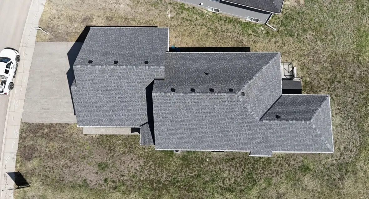 Straight down drone photo of a finished multi gable shingle roof on a new home