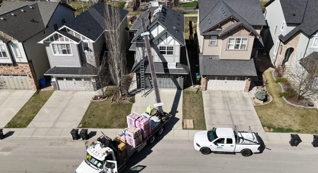 Aerial view of an All About Exteriors truck loaded with shingles on a residential street