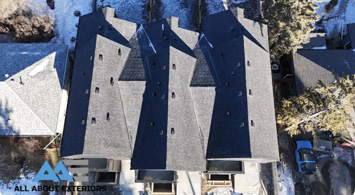 Drone photo of a row of finished shingle roofs on attached homes