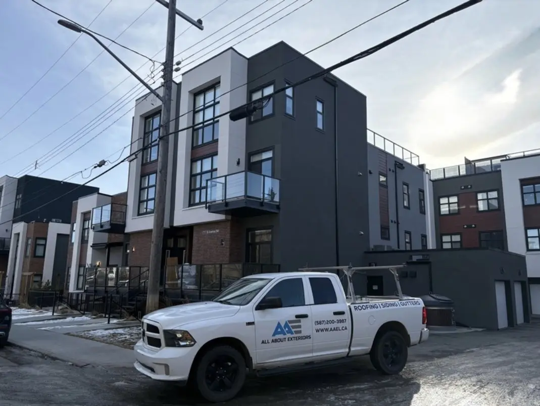 All About Exteriors truck parked at a modern three storey infill with dark panel cladding