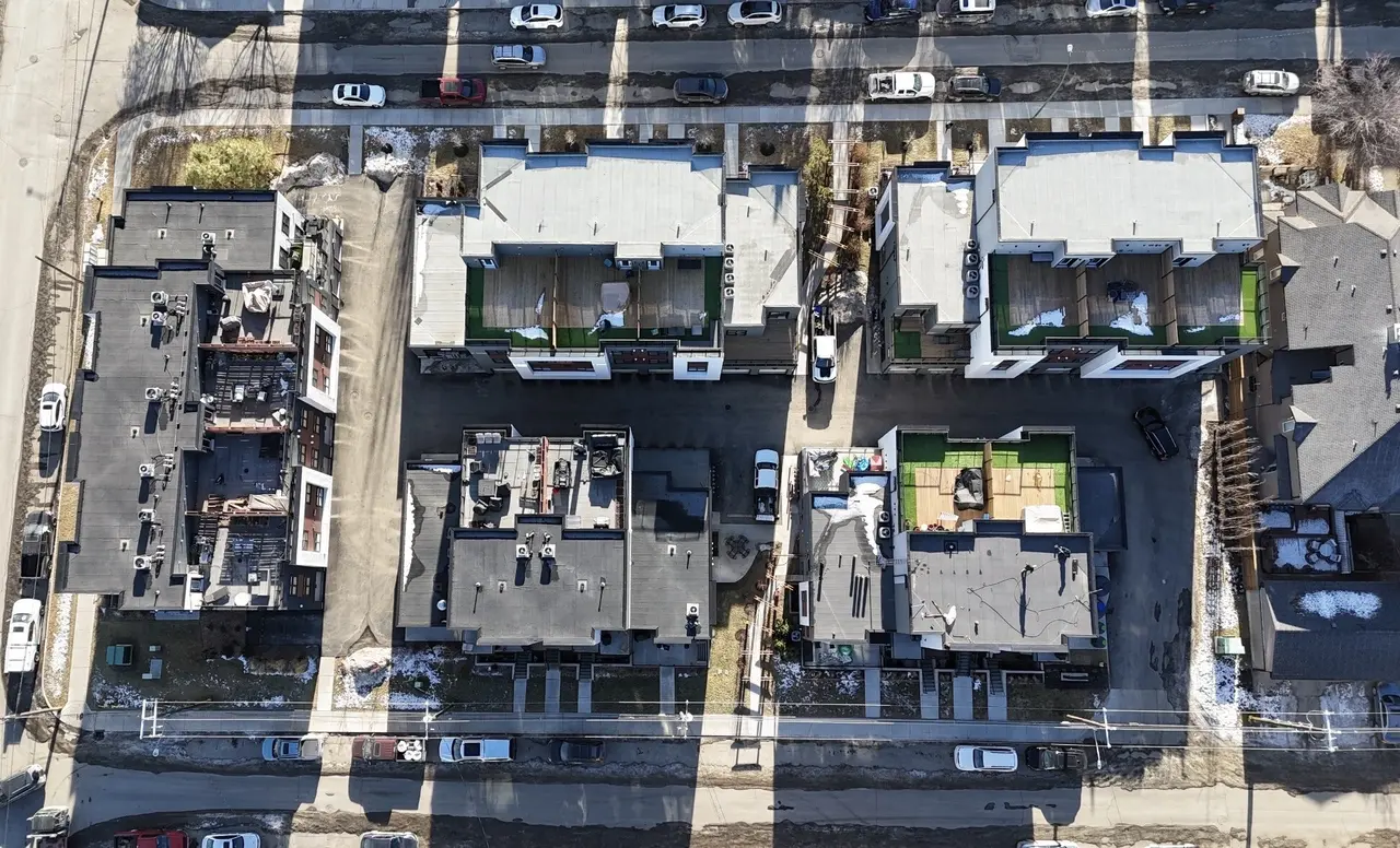 Drone view over a townhome development under construction with rooftop decks