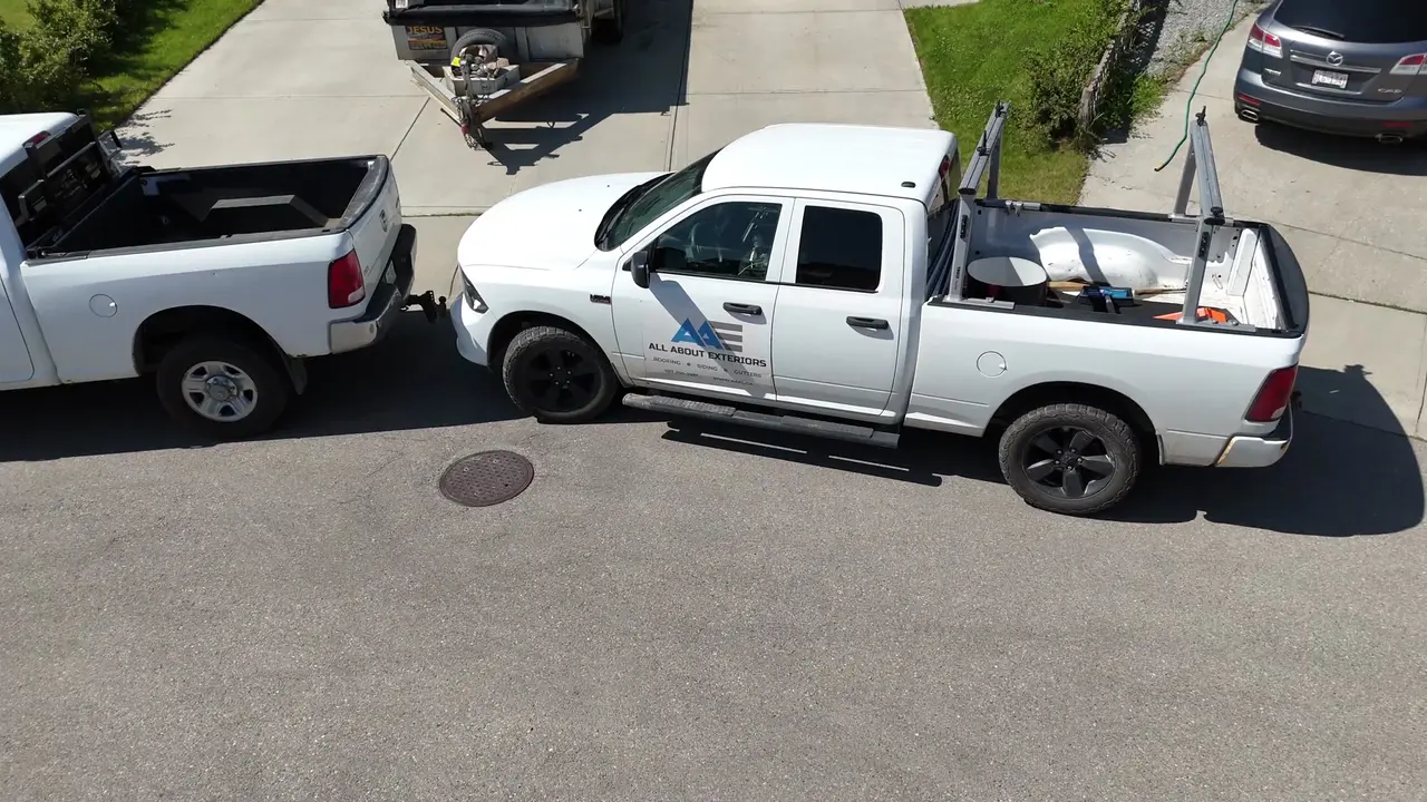 Drone video of an All About Exteriors truck arriving and the camera rising over a two storey reroof in underlayment