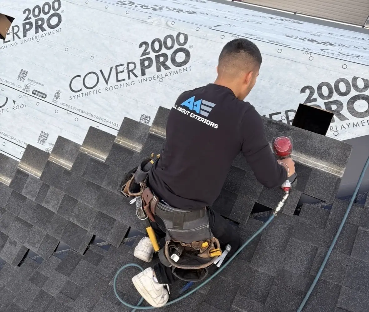 Roofer nailing shingles up to CoverPro 2000 synthetic underlayment around a roof vent
