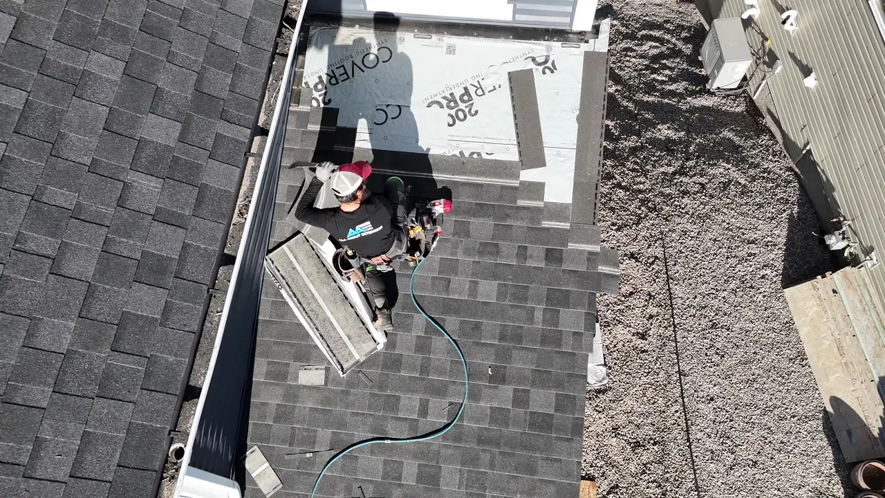Drone video of a roofer installing a vent boot over synthetic underlayment